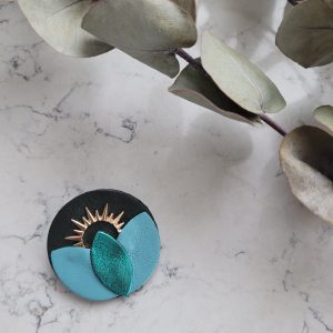 Broche ronde en cuir solaire dans les coloris turquoise